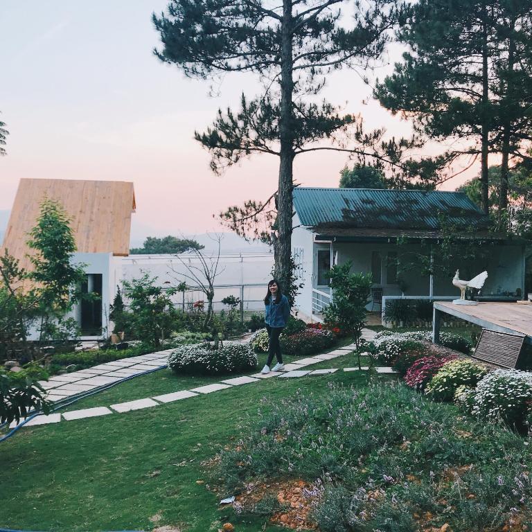 a woman standing in front of a house at Farm'ily in Da Lat