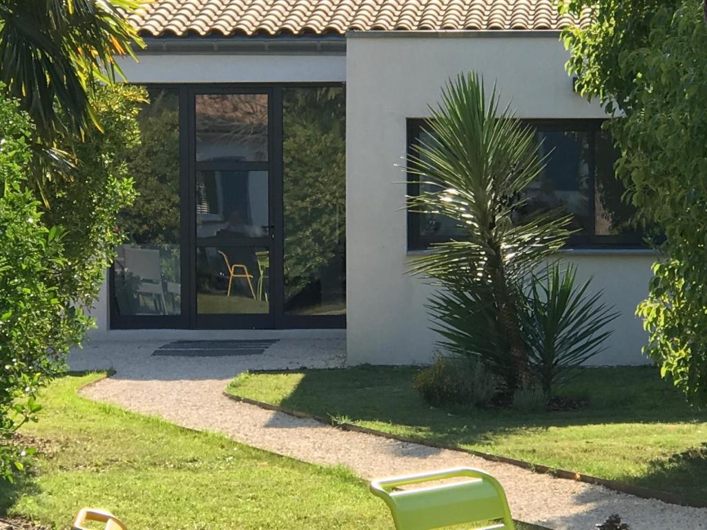 uma casa branca com uma cadeira à frente. em Le Cherche Midi, entre Nîmes, le Pont du Gard, Uzès, Arles em Marguerittes