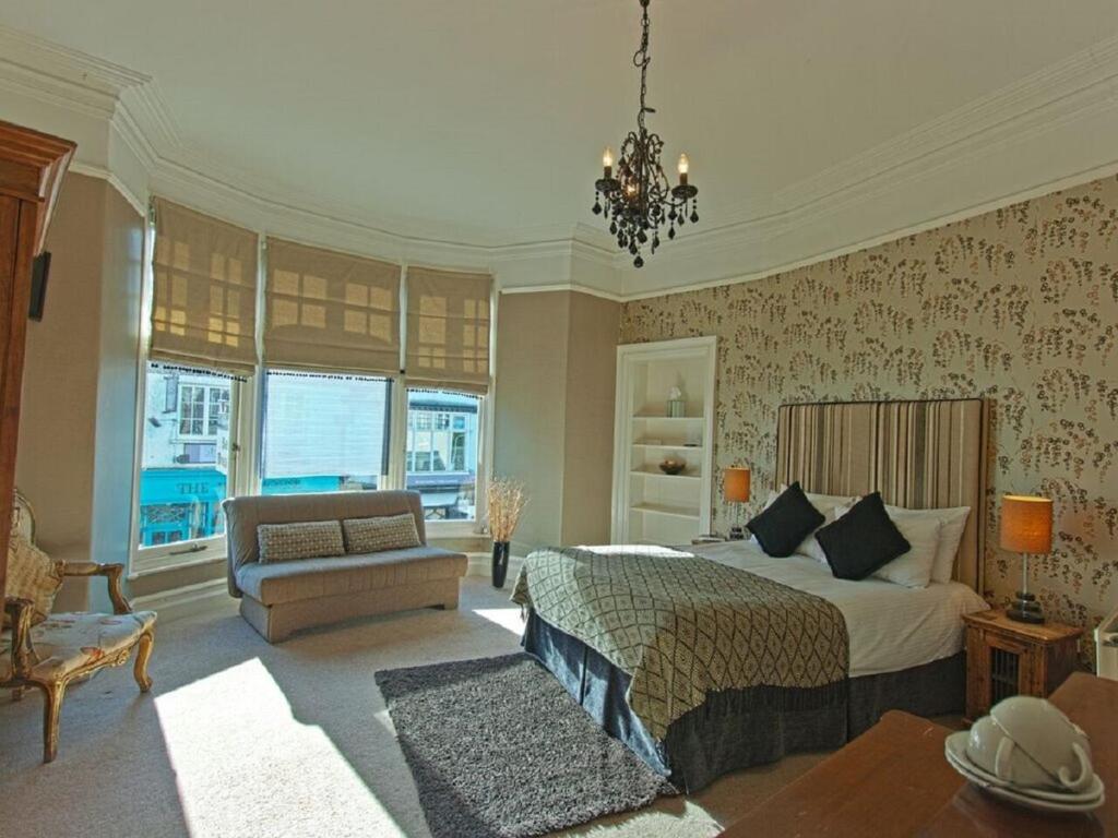 een grote slaapkamer met een bed en een bank bij Monties Guest House - Adults ONLY in Bowness-on-Windermere