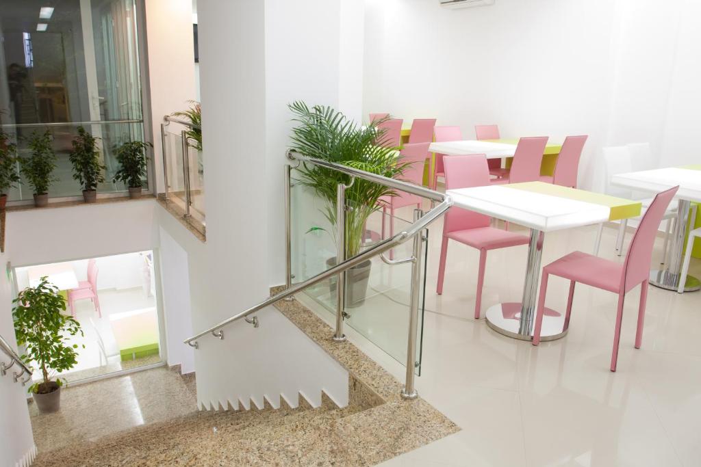 une salle à manger avec des chaises roses et une table dans l'établissement Christina Hotel, à Bucarest