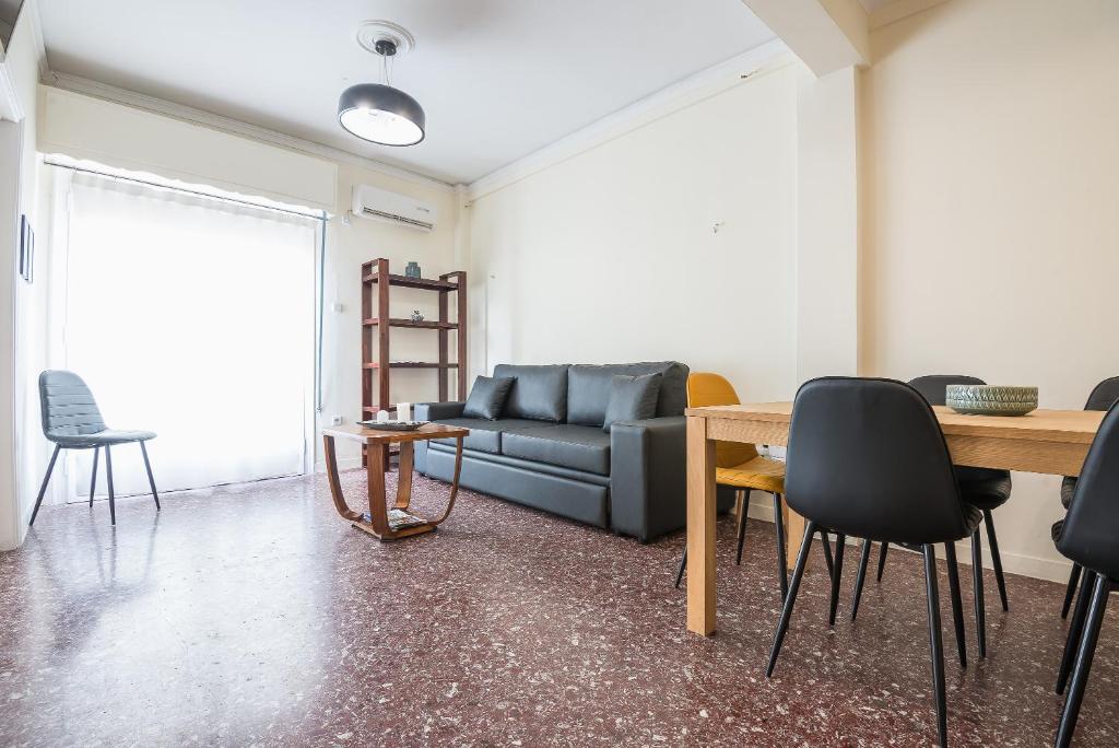 a living room with a couch and a table and chairs at Acropolis View Paradise Apartments in Athens