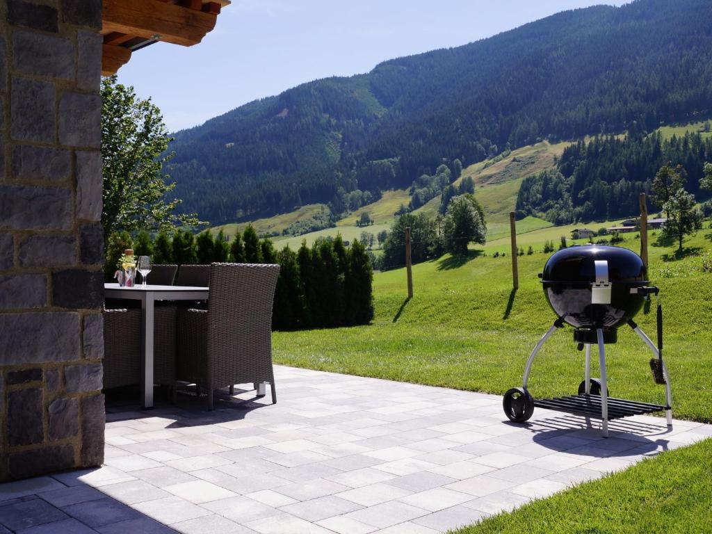 - un barbecue sur une terrasse avec une table et des montagnes dans l'établissement Chalet in Salzburg with sauna near ski area, à Leogang