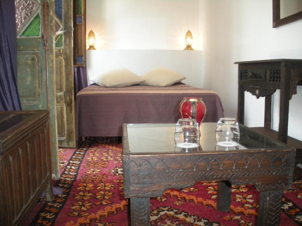 a bedroom with a bed and a table with glasses on it at Riad Arous Chamel in Tangier