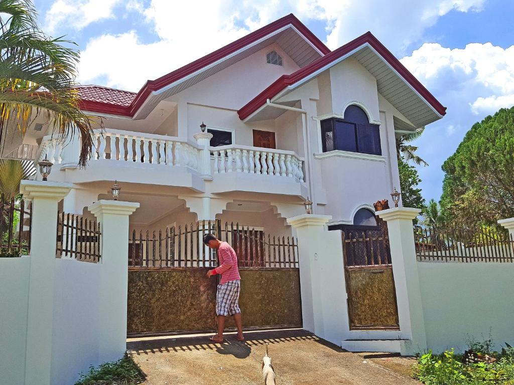 a man standing in front of a white house at Sofias House Rental in Tagbilaran City