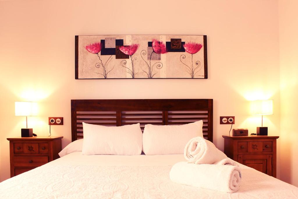 een slaapkamer met een bed met roze bloemen aan de muur bij Casa del Agua in Anna