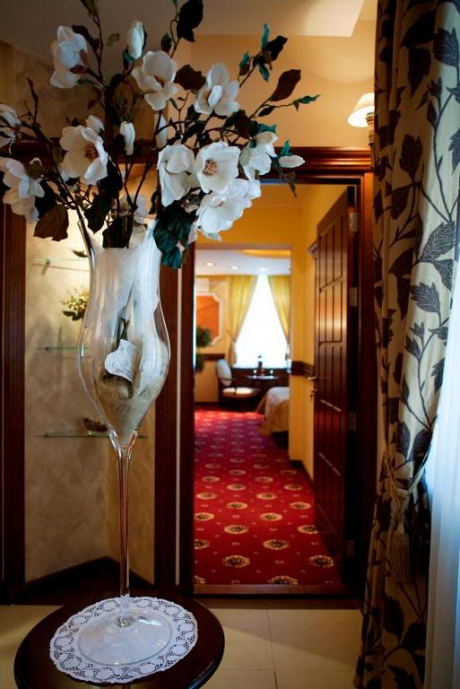 a vase with white flowers on a table in a room at Manjež Centar in Belgrade