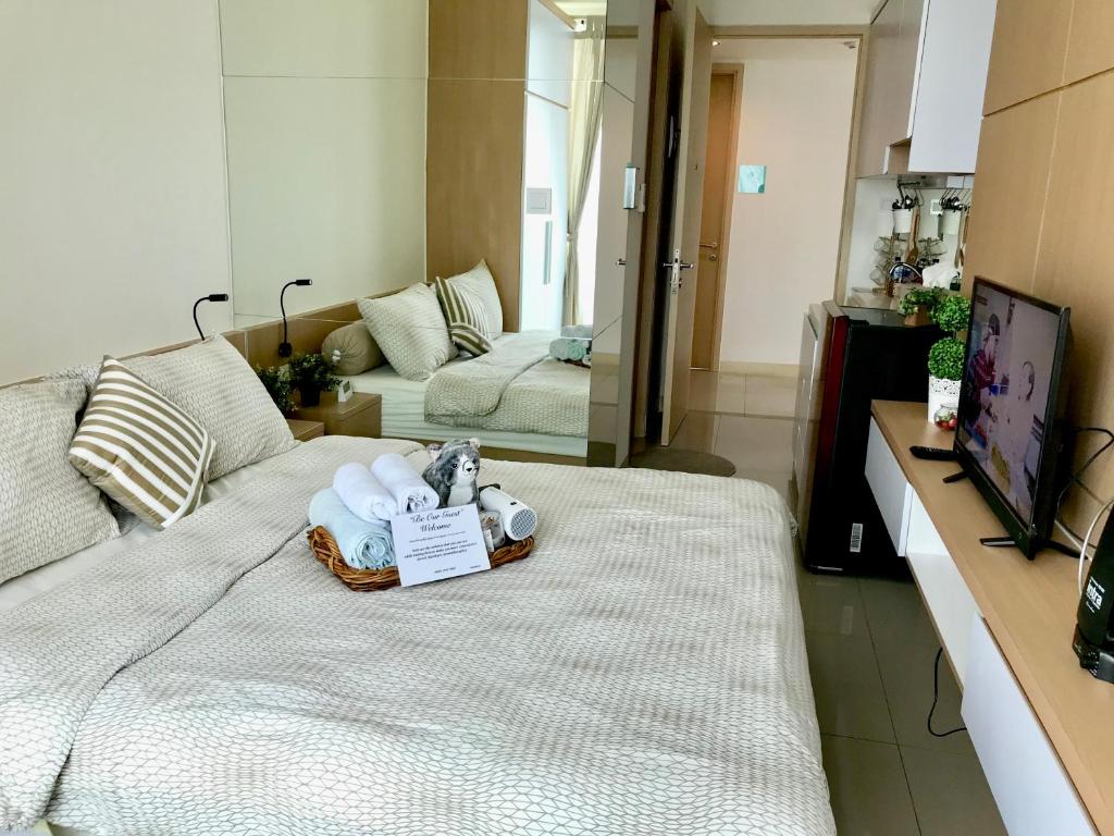 a room with a bed with towels on it at Apartment Tree Park BSD - 2101 in Serpong