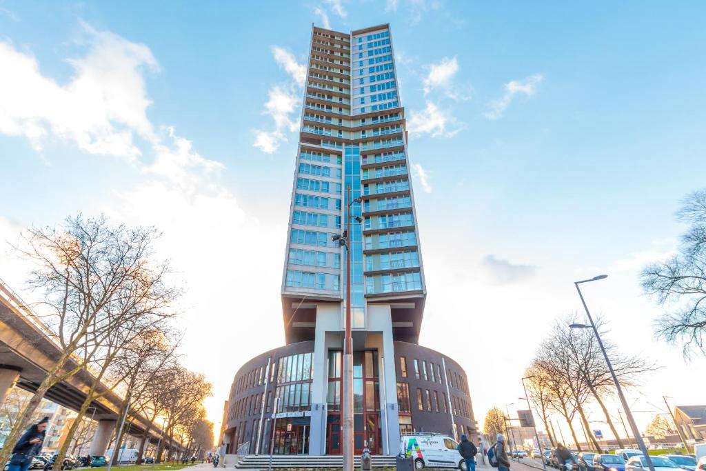 a tall glass building in a city with a sky at ART Hotel Rotterdam-Fully Renovated in Rotterdam