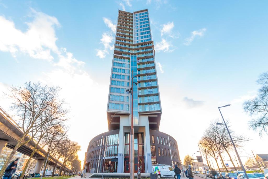 Un edificio di alto vetro in una città con il cielo di ART Hotel Rotterdam-Fully Renovated a Rotterdam