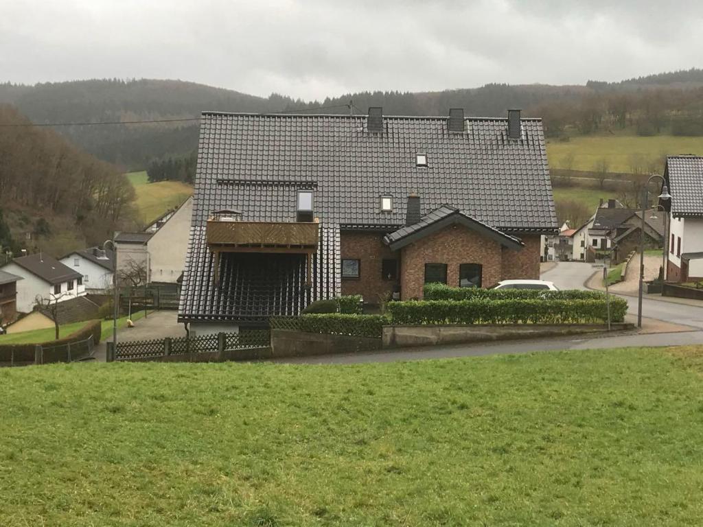 a house with a large roof on a street at Appart-Ascolino in Siebenbach