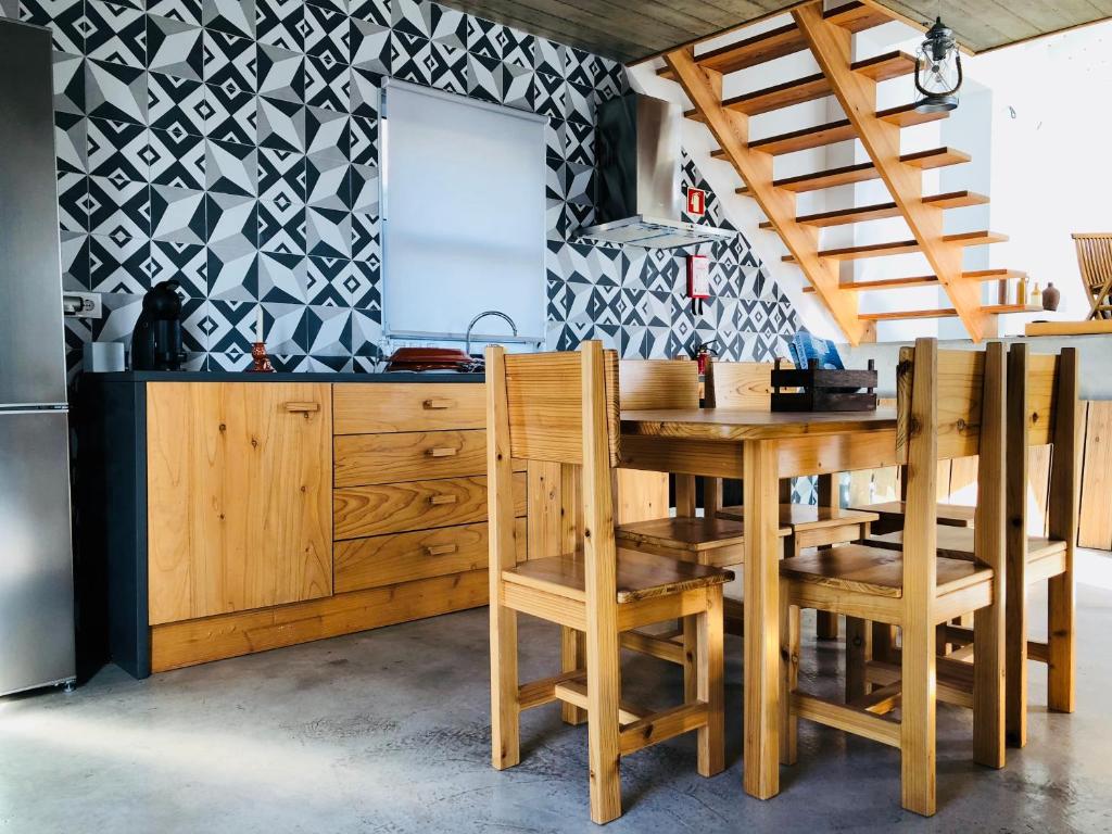 a kitchen with a wooden table and chairs at Casa d'Avó Francisco in Madalena