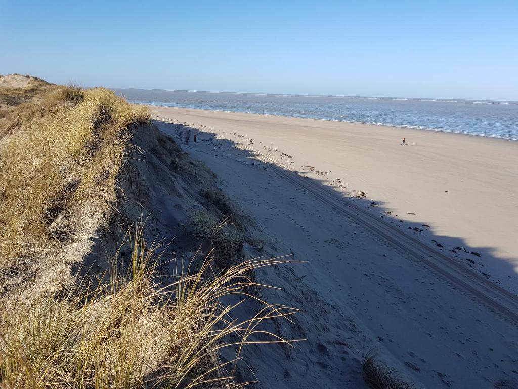 a sandy beach next to the ocean at Studio Mb in Ouddorp