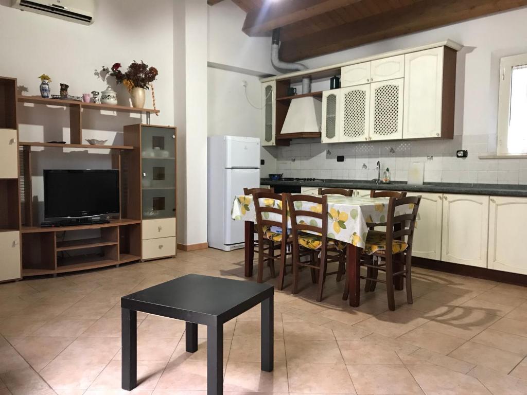 cocina con mesa y sillas y TV en Elisabeth, en San Benedetto del Tronto