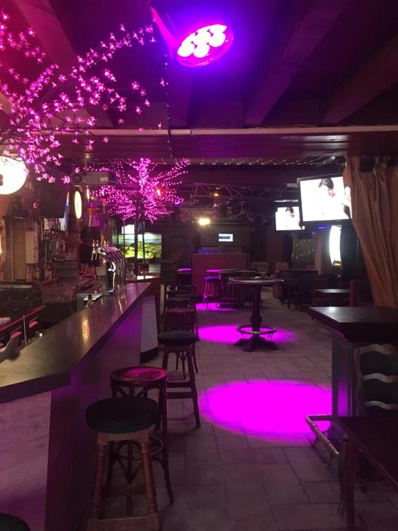 a bar with purple lights in a restaurant at Hotel du Rempart in Sancerre
