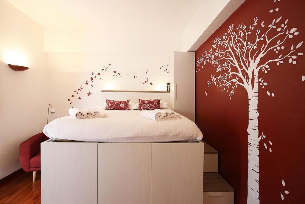 a bedroom with a bed with a tree mural at Suite Fiera Milano City in Milan