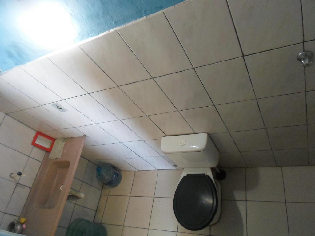 Un baño con inodoro y techo de baldosas. en estudio, en Salvador
