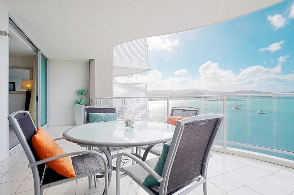 a dining room with a balcony overlooking the ocean at at Marina Shores in Airlie Beach