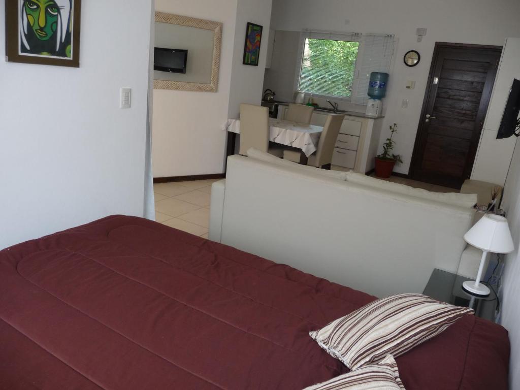 a bedroom with a bed and a living room at Rincón Del Golf in Pinamar