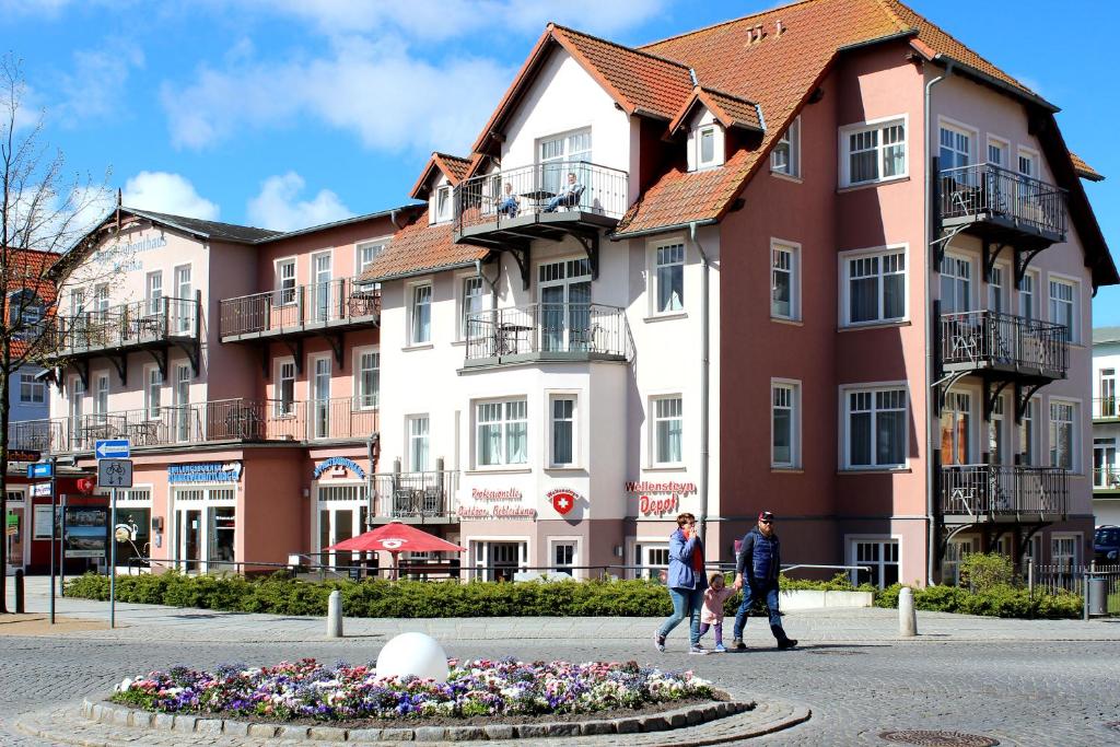 un grupo de personas caminando delante de un edificio en Appartmenthaus Monika en Kühlungsborn