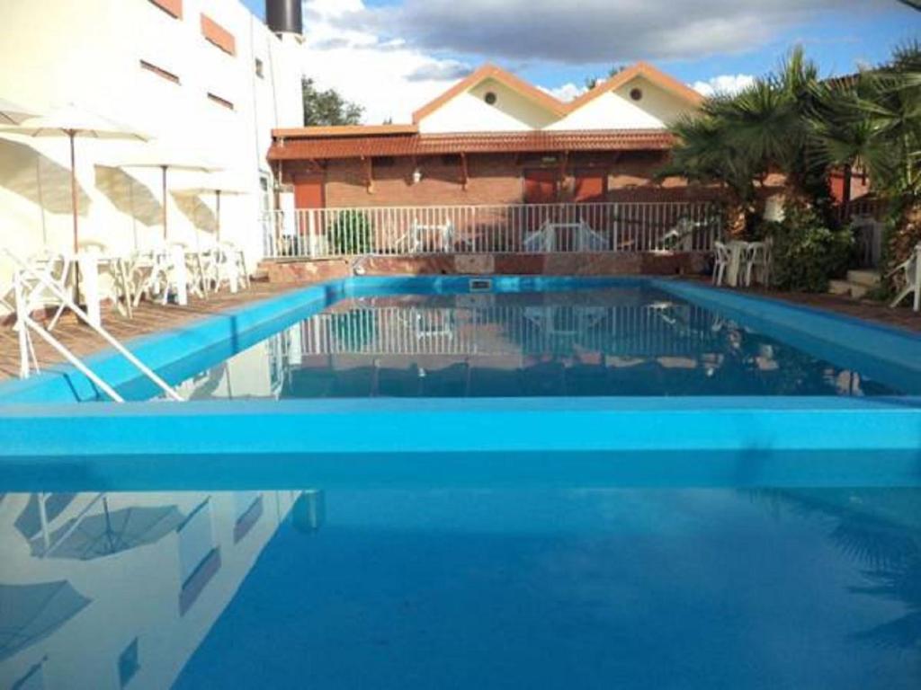 una piscina azul frente a una casa en Hotel Car Mar en Mina Clavero