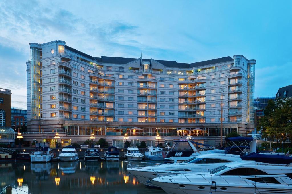 a large building with boats docked in a marina at The Chelsea Harbour Hotel and Spa in London