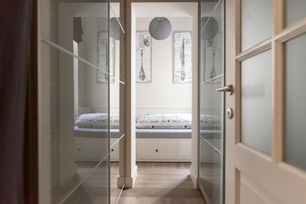 una puerta de cristal que conduce a un dormitorio con cama en Cozy & Bright Apartment, en Amberes