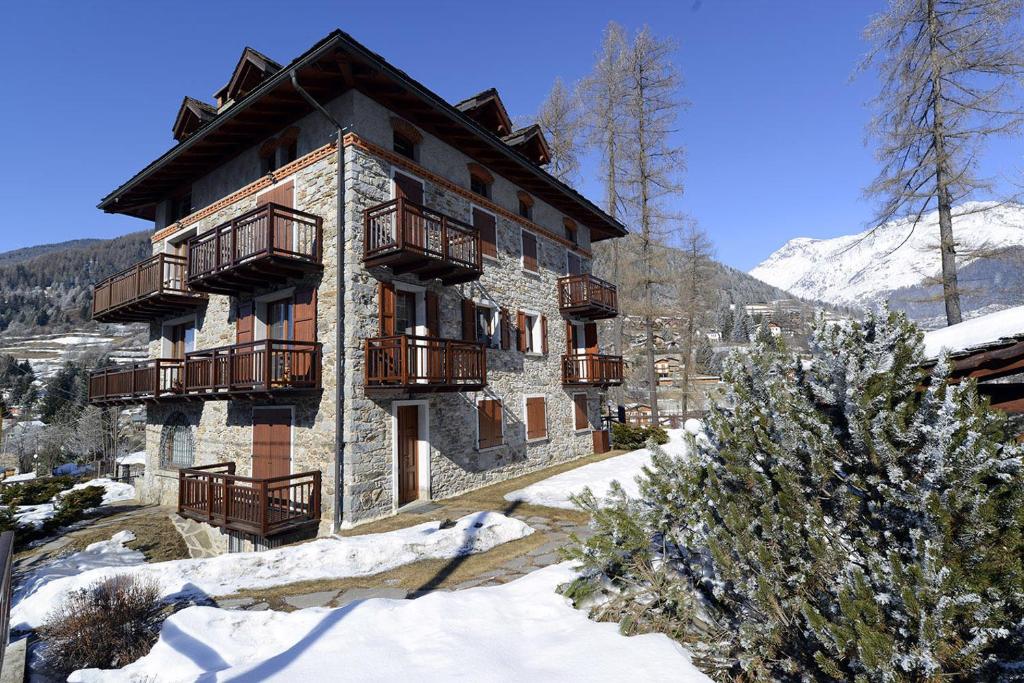 un edificio con balconi e neve al suolo di Villa Sorriso a Ponte di Legno