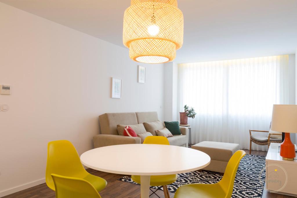 un soggiorno con tavolo e sedie gialle di Oporto Ceuta Residences - Residence 1 by We Do Living a Porto