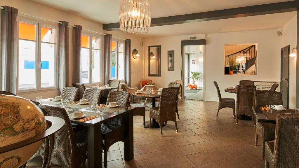 a restaurant with tables and chairs and a chandelier at Résidence La Chaize in Noirmoutier-en-l'lle