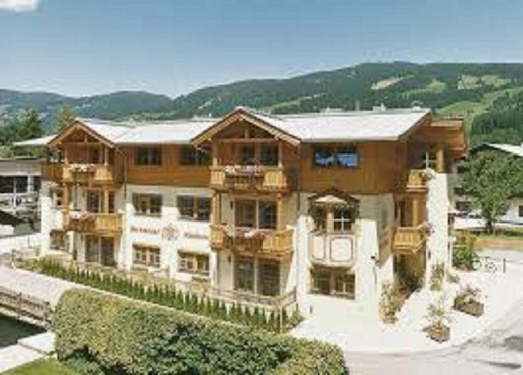 a large wooden house with a balcony on the side of it at Ferienhaus Hotel Rösslwirt in Kirchberg in Tirol