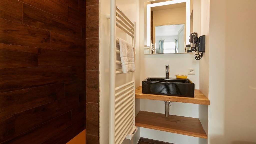 a bathroom with a sink and a mirror at Logis Hôtel La Chaize in Noirmoutier-en-l'lle