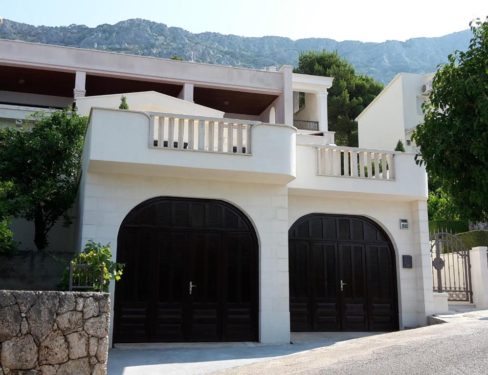 a house with two garage doors in front of it at Guest house Fenix Brela in Brela