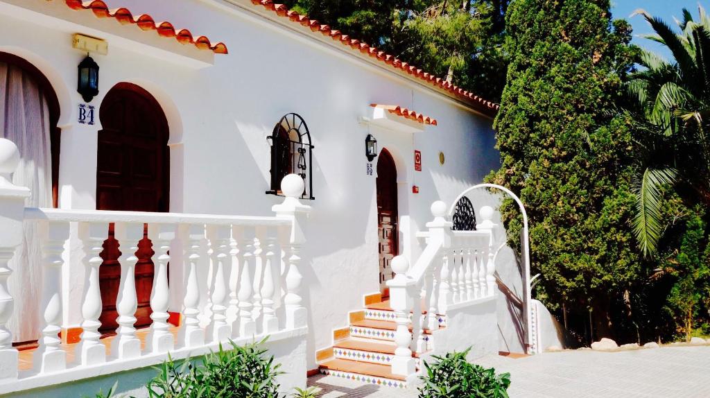 a white house with stairs and trees at Granada Apartments Familiar Deluxe in Portinatx