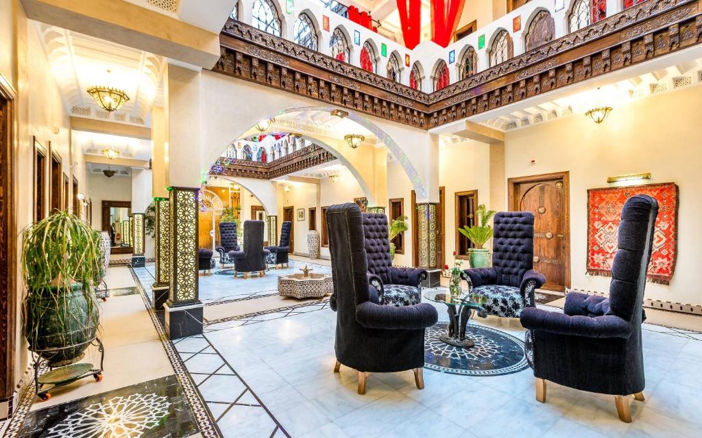 eine Lobby mit Stühlen und Tischen in einem Gebäude in der Unterkunft Hotel & Ryad Art Place Marrakech in Marrakesch