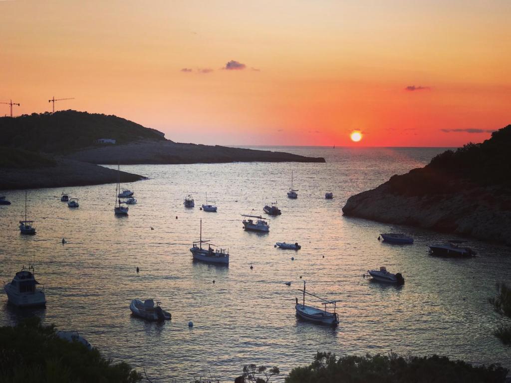 a group of boats in the water at sunset at Granada Apartments Familiar Deluxe in Portinatx