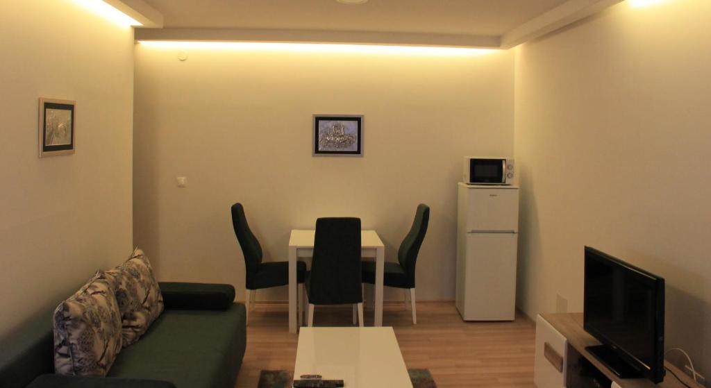 a small living room with a table and a couch at "E&S" Apartment in Mostar