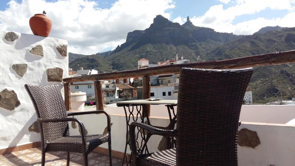 2 Stühle und ein Tisch auf einem Balkon mit Bergblick in der Unterkunft Casa Canaria Tejeda in Tejeda