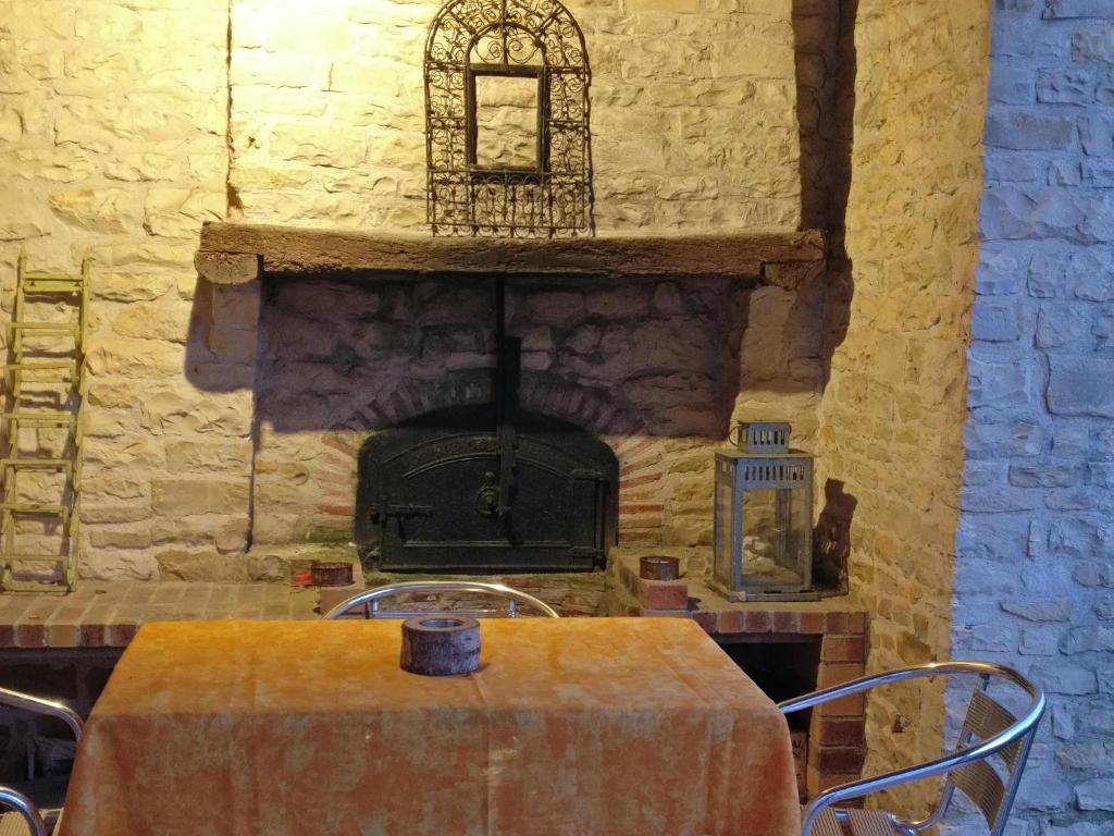 a stone wall with a table and a fireplace at Des Km à La Ronde in La Ronde