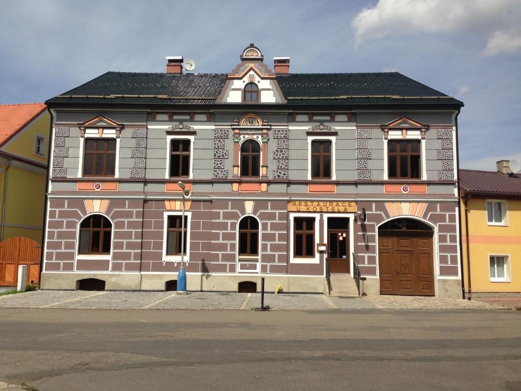 ein großes Backsteingebäude mit brauner Tür in der Unterkunft Restaurace U Kostela in Mariánské Radčice