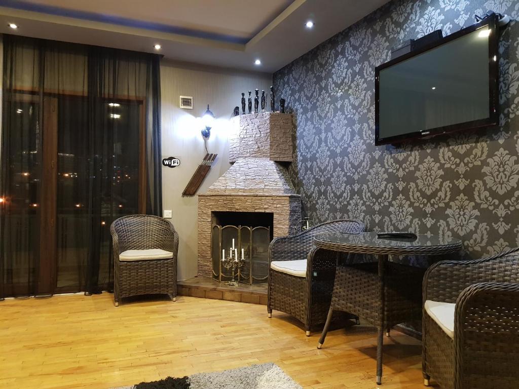 a living room with a fireplace and a flat screen tv at Apartment Old Tbilisi Gorgasali in Tbilisi City