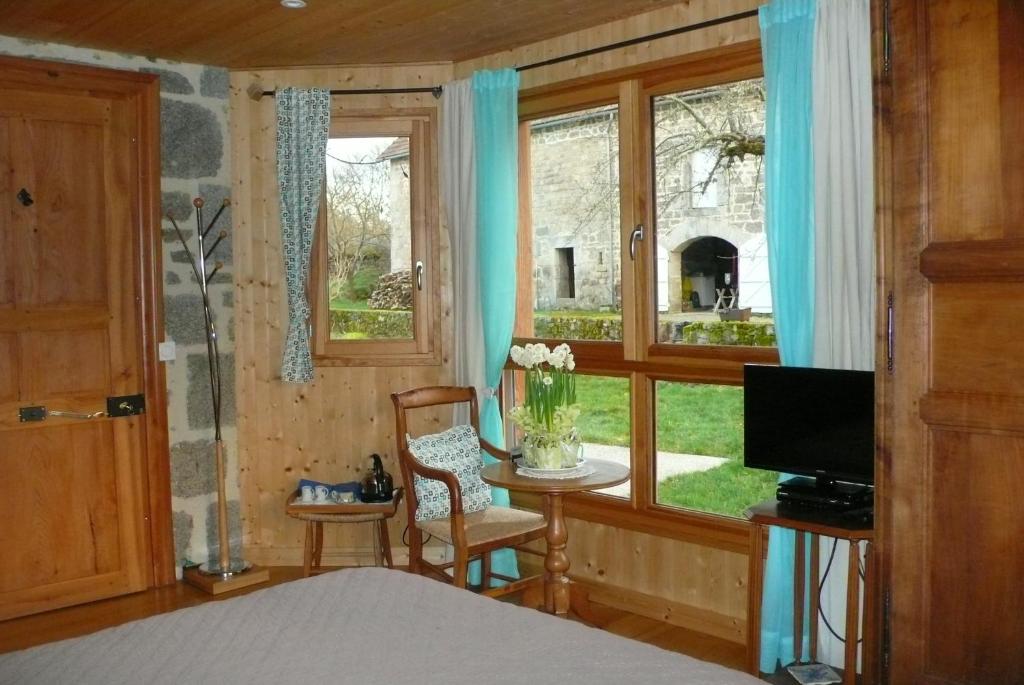 a bedroom with a bed and a table and a window at chez Geppetto in Saint-Georges-Nigremont