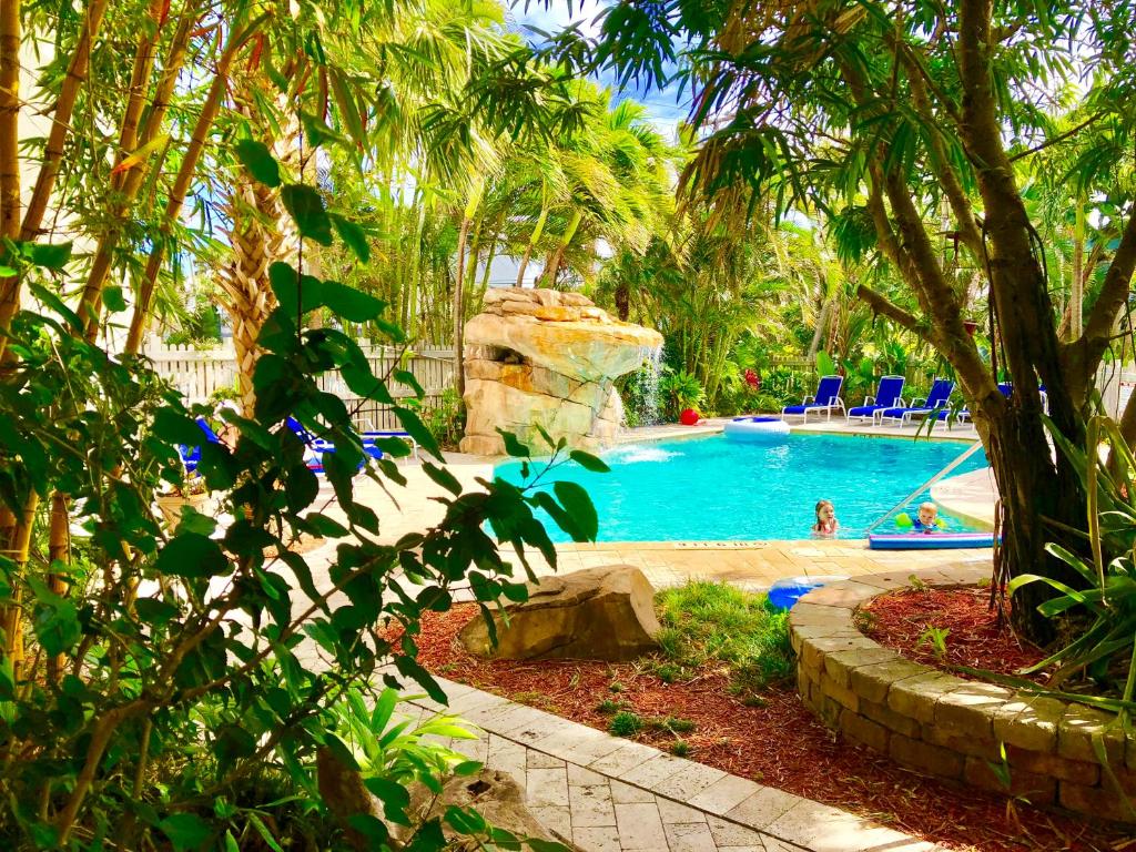 una piscina en un complejo con palmeras en Riverside Apartments By The Beach en Pompano Beach