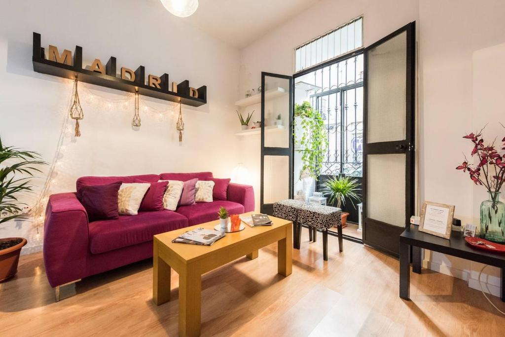 a living room with a purple couch and a table at Apartamento en Calle Tres Peces in Madrid