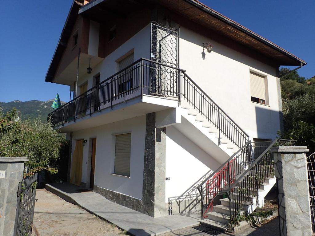 ein weißes Gebäude mit einer Treppe und einem Balkon in der Unterkunft Casetta al Mare in Giustenice