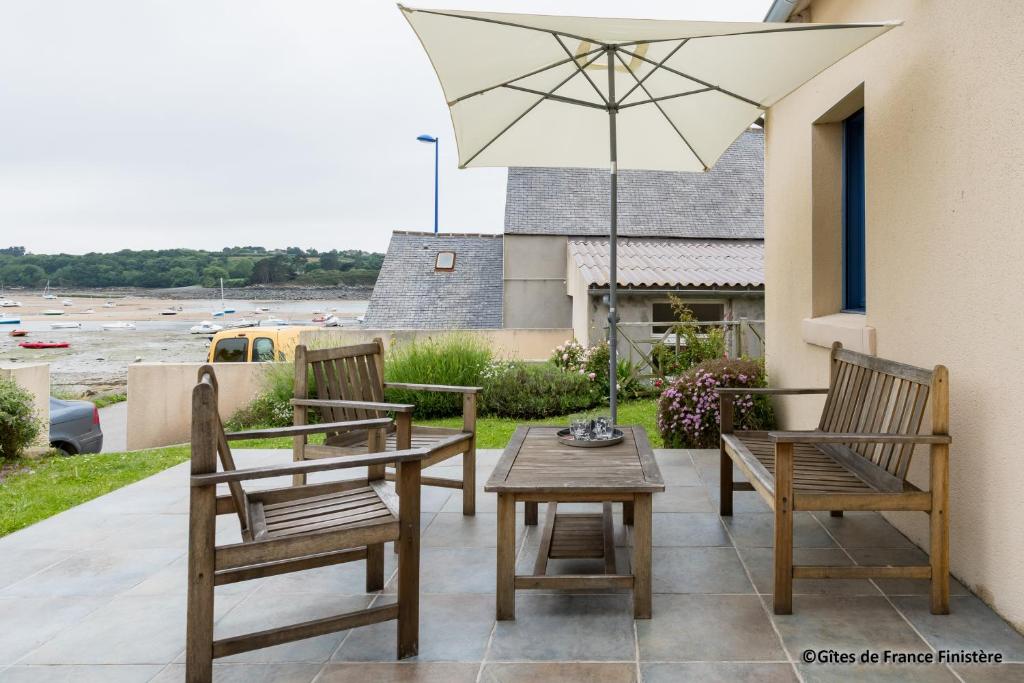a patio with two chairs and a table and an umbrella at La maison du port in Plougasnou