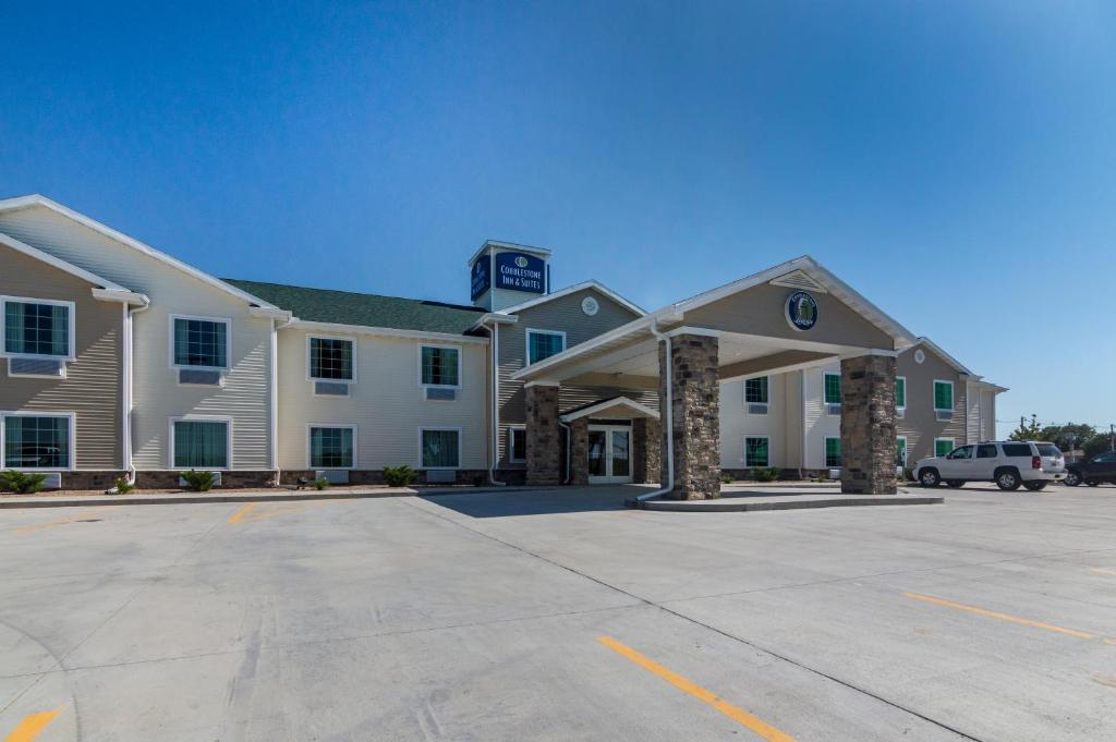 a large white building with a parking lot at Cobblestone Inn & Suites - Lakin in Lakin
