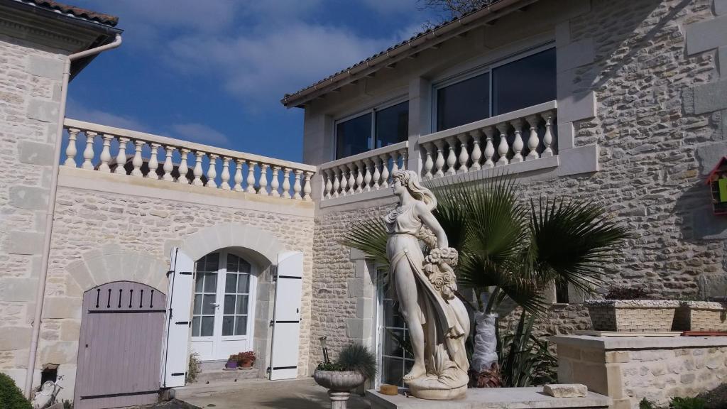 una estatua de una mujer frente a una casa en LES ORCHIDEES Ch Hôtes B&B 14 personnes Jaunay-Clan, en Jaunay-Clan