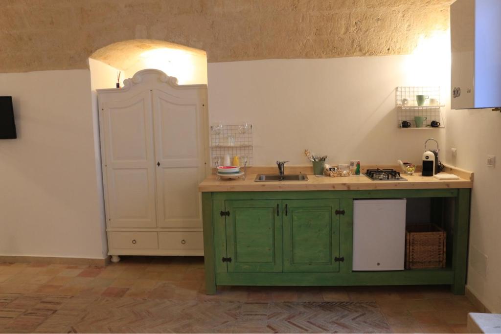 a kitchen with a green cabinet and a sink at Casa Ela in Matera