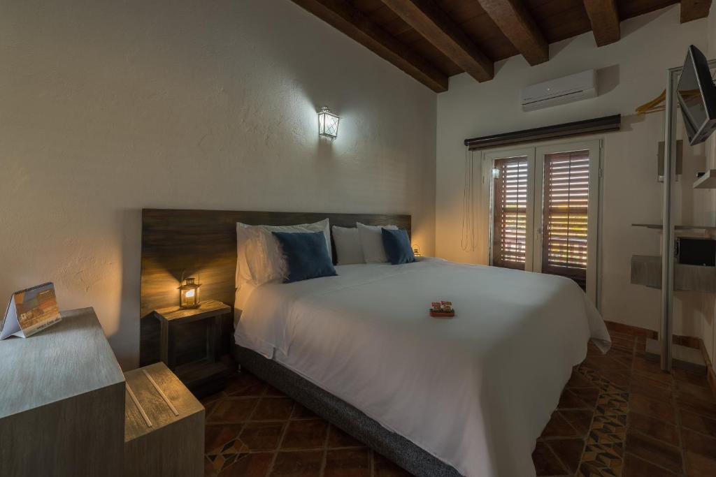Postel nebo postele na pokoji v ubytování Getsemani Cartagena Hotel