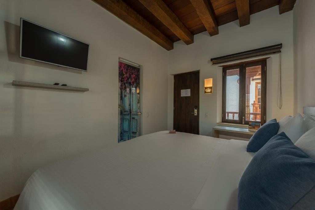 Postel nebo postele na pokoji v ubytování Getsemani Cartagena Hotel